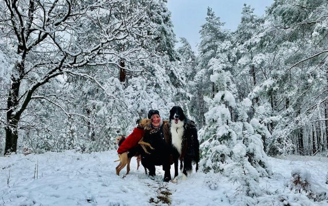Monika Mosch mit Windhunden im verschneiten Wald